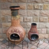 Two Mexican Chimineas up against stone cladded walls.
